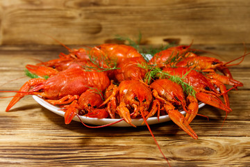 Boiled crayfish in plate on wooden table