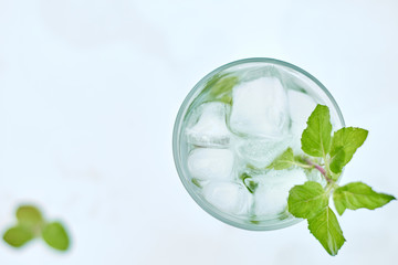 Summer hot fresh drink with mint in glass on white green grey background