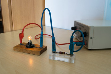 Electrical experiment in physics laboratory. Electrical circuit with resistance and light bulb.