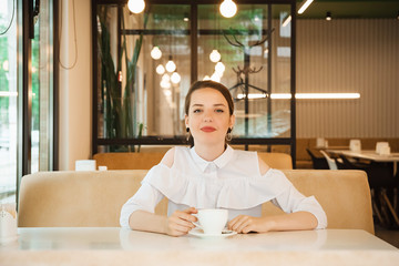 business girl drinks a drink in a cup