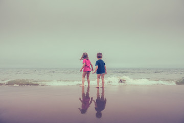 Little boy and girl standing in the sea