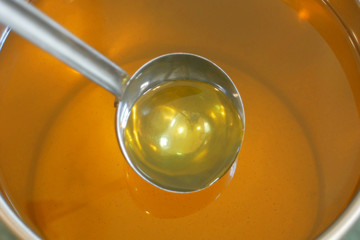 Sunflower oil organic quality bio, mixing and pouring in a steel barrel, for cold food and fried foodstuff, healthy cooking, gold seeds, vegetarian cuisine, filling bowl, bubbles active
