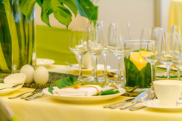 Luxury party dinner table setting with tableware and silverware and glasses set and Candlestick and flower in restaurant.