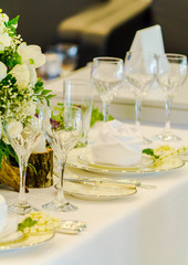Luxury party dinner table setting with tableware and silverware and glasses set and Candlestick and flower in restaurant.
