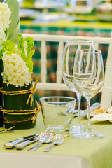 Luxury party dinner table setting with tableware and silverware and glasses set and Candlestick and flower in restaurant.