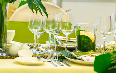 Wedding party dinner table setting with tableware and silverware and glasses set and Candlestick and flower in restaurant.