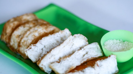 Pancong cake or kue pancong and sugar on white background. Street food in Jakarta, Indonesia. 