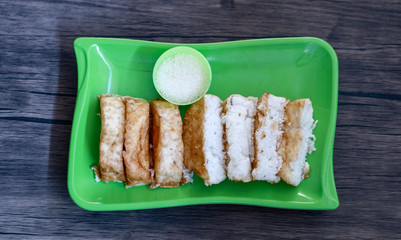 Pancong cake or kue pancong and sugar on wood background. Street food in Jakarta, Indonesia. 