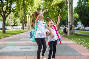 Naklejka premium Back to school education concept with girl kids, elementary students, carrying backpacks going to class