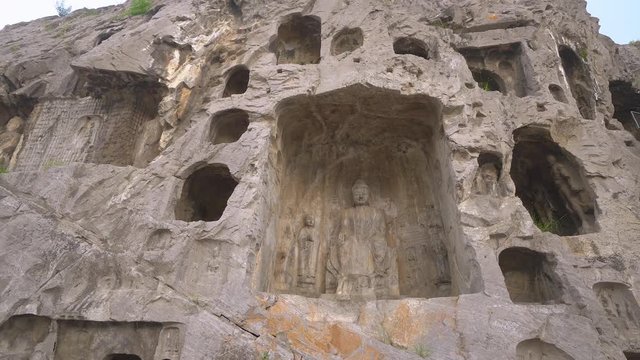 Longmen Grottoes or Longmen Caves dated from 5th century. Thousands of ancient statues of Buddha carved inside the mountain at Luoyang in Henan province, China