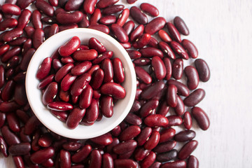 Red beans in white bowl on wooden background.