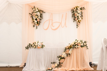 Wedding table decorated with flowers and peach fabric