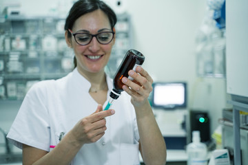 Female doctor preparing syringe for vaccination