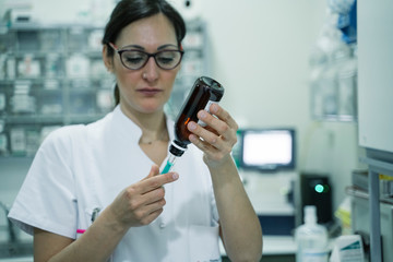 Fototapeta na wymiar Female doctor preparing syringe for vaccination
