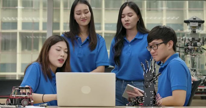 Young asian creative engineers meeting, programming for collaborative universal robotics at laptop in workshop. People with technology or innovation concept.