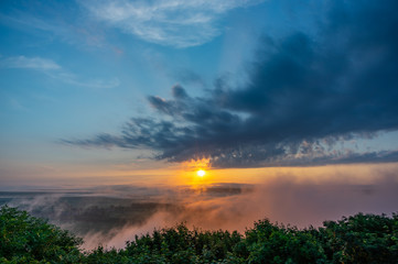 Dawn on a misty morning on a mountain above the river