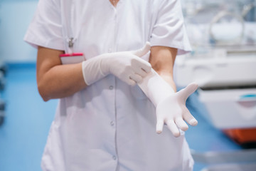 Female doctor working putting her medical gloves