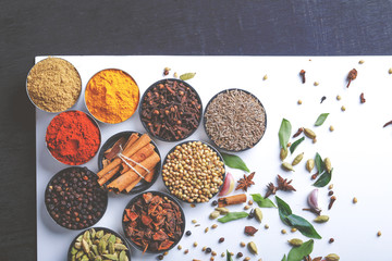 Various spices in a bowls on white background. Top view with copy space.