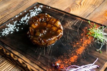 Grilled meat with spices and sauce on a wooden table.	