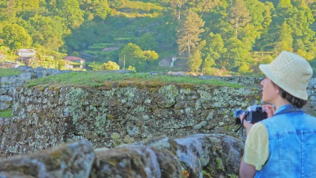 Tourist takes pictures of Castle ruins in Peneda-Geres national park.