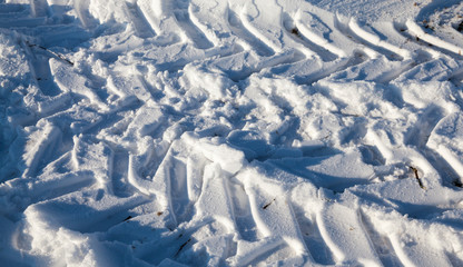 Fototapeta na wymiar Traces of the car on the snow