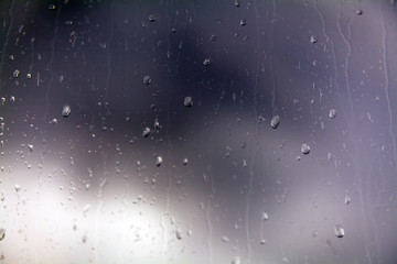raindrops on glass in cloudy weather close up