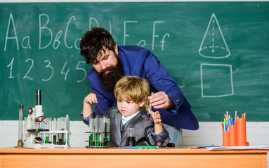 Teacher and child school classroom. Chemistry lesson. Lab experiment. Primary school. Basic education. Childhood upbringing and education. Boy pupil achieving education. School education concept