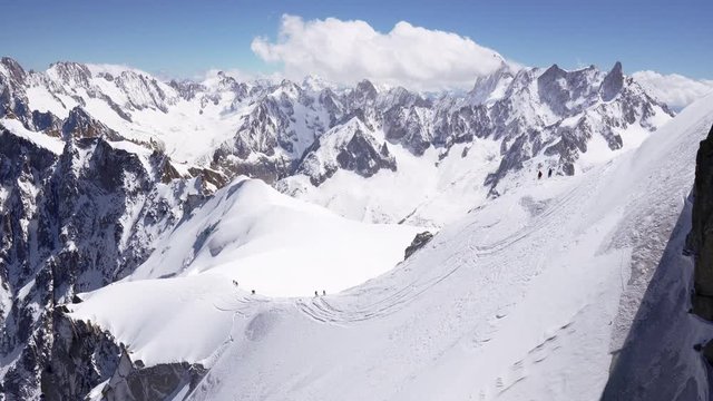 a group of climbers climbs the snow-capped peaks of the alpine mountains.