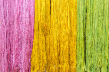 Thai silk threads fiber background in pink, green and yellow color