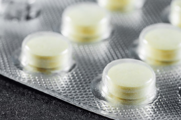Bright yellow pills in sticks, closeup
