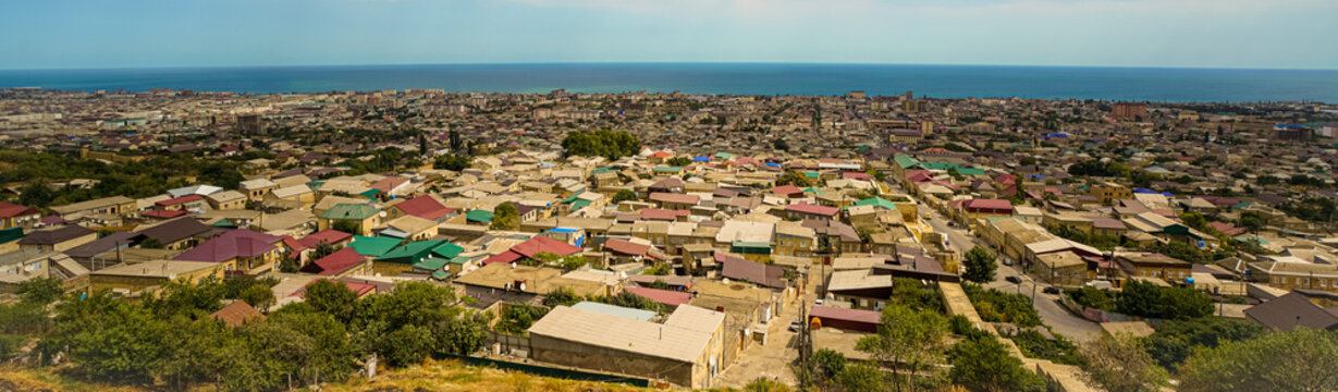 Panorama Of The City Of Derbent, Lying On The Shores Of The Caspian Sea, From The Observation Deck At The Naryn-Kala Fortress. The City Is Half Illuminated By The Sun, The Other One Is In The Shade