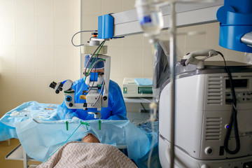The ophthalmologist performs operations in the operating room, delicate work with the eyes, eye operations, the patient lies in front of the doctor
