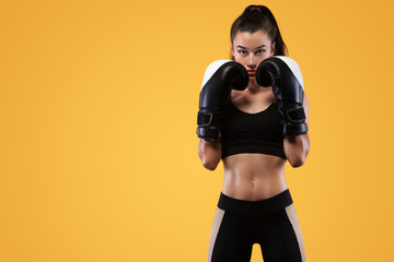 Sportsman, woman boxer fighting in gloves. on yellow background. Boxing and fitness concept.