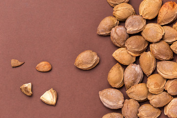 Top view of apricot kernels on brown background