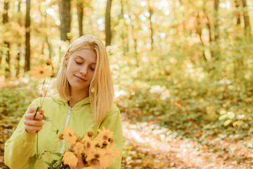 Collecting forest flowers. Blonde enjoy relax forest. Autumn bouquet. Warm autumn. Girl with flowers. Woman walk autumn forest defocused background. Weekend activity. Simple autumnal pleasures