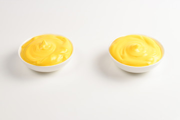 Cheese sauce in white plate on white background.