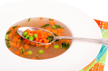 Dietary vegetable soup with carrots, peas and green onions. 