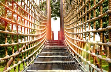 wooden bridge with strong robe at playground perspective