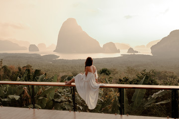Woman with the white dress sit and see the mountain in early morning at the Sametnangshe Island...