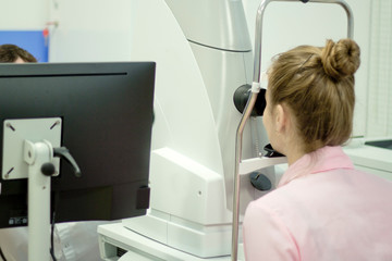 A young woman undergoes an ophthalmological examination, checking the health of the eyes and visual acuity.