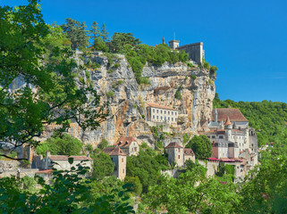 Fototapeta premium Landscape view through the forest of the medieval french village of Rocamadour, on a cliff of the alzou river valley, Lot Department, Quercy, Occitanie Region, France. UNESCO world heritage site.