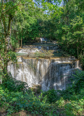 Fototapeta na wymiar Many waterfalls flow in the frame of plants and green trees. Huai Mae Kamin Waterfall Viewpoint, Kanchanaburi Province