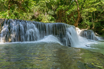 The clean waterfall there is an emerald green colour caused by reflections from trees and lichen circulating through the yellow limestone. Huai Mae Khamin Waterfall, Kanchanaburi Province