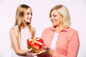 Surprise! I love my grandma. Family holidays and celebrations. Close up photo of happy grandmother and granddaughter in good and fun mood isolated together on white background.