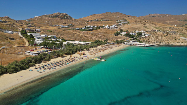 Aerial drone photo of famous organised with sun beds and umbrellas beach of Kalo Livadi with emerald clear sandy sea shore, Mykonos island, Cyclades, Greece  