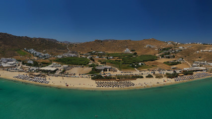Aerial drone photo of famous organised with sun beds and umbrellas beach of Kalo Livadi with emerald clear sandy sea shore, Mykonos island, Cyclades, Greece  