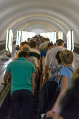People in the subway on the escalator. A crowd of people on the stairs in the subway. vertical photo
