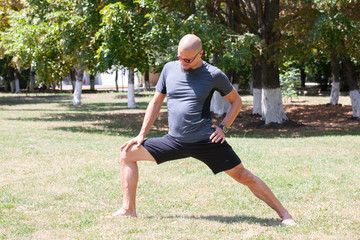 Man exercising in park. Smiling caucasian male doing core workout on grass.