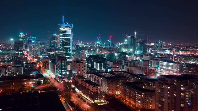 Aerial hyperlapse of Warsaw business center at night: skyscrapers and Palace of Science and Culture