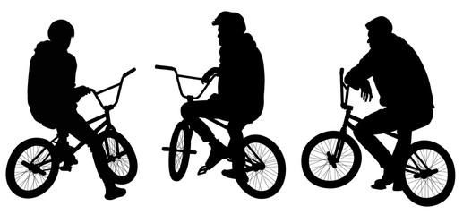 Silhouettes of tree teenagers sitting on bicycles